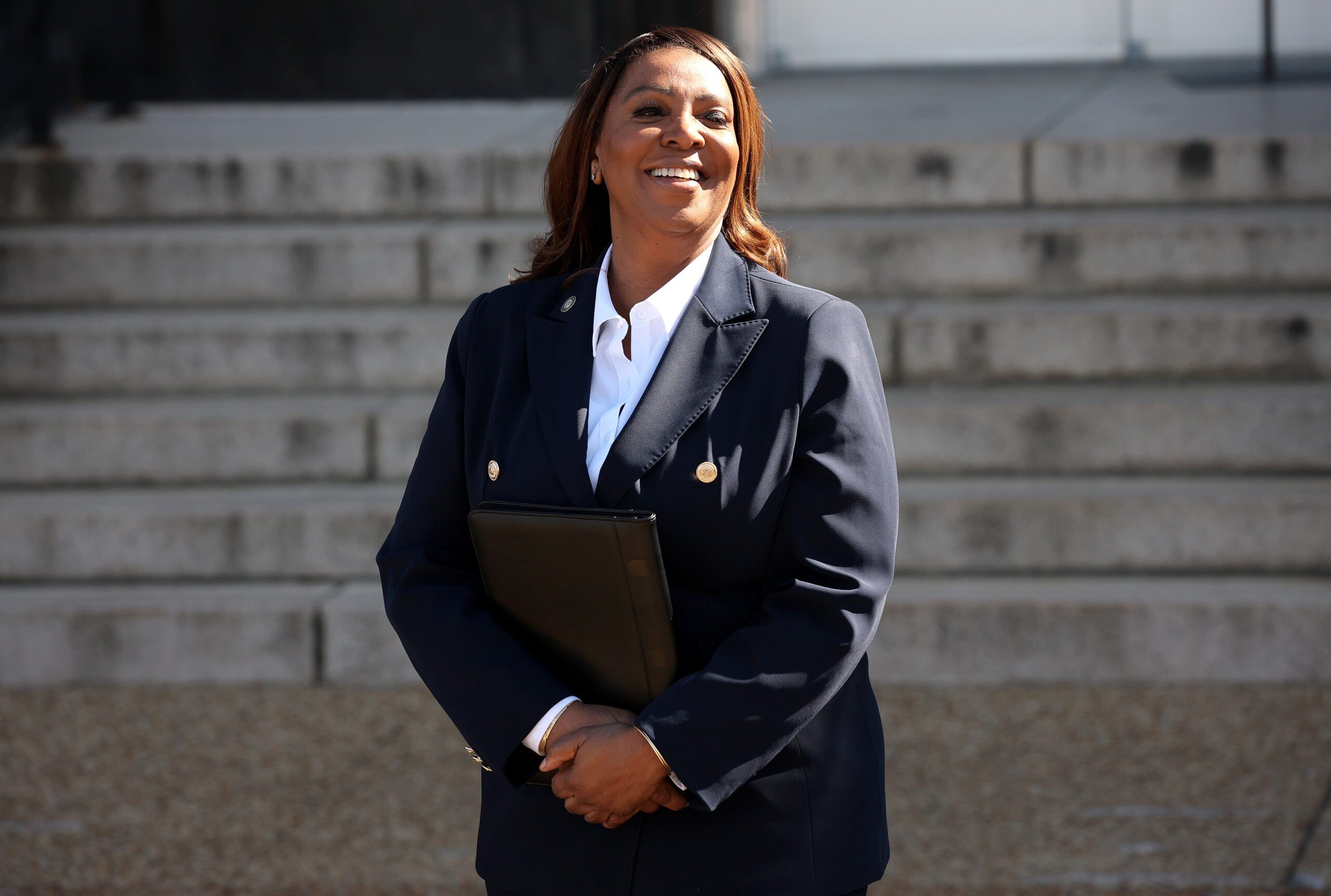 New York Attorney General Letitia James after appearing In Federal Court. Smiling with the sun on her face